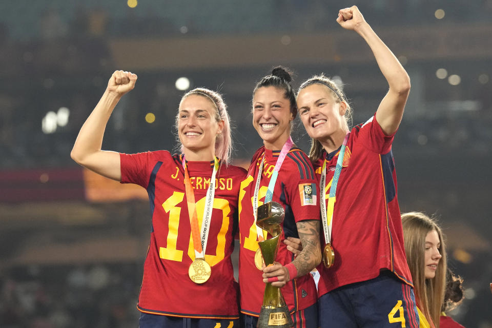 Spain's Alexia Putellas, Jennifer Hermoso and Irene Paredes ,from left, celebrate with the trophy at the end of the Women's World Cup soccer final between Spain and England at Stadium Australia in Sydney, Australia, Sunday, Aug. 20, 2023. Spain won 1-0. (AP Photo/Alessandra Tarantino)