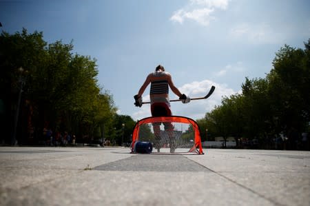 A player in a weekly pick up hockey game stands in front of the net along Pennsylvania Avenue near the White House during a heat wave in Washington