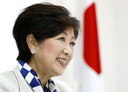 Tokyo Governor Yuriko Koike, head of Japan's Party of Hope, smiles next to a Japanese national flag during an interview with Reuters in Tokyo, Japan October 6, 2017. REUTERS/Issei Kato