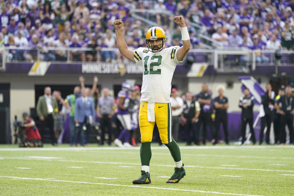 Green Bay Packers quarterback Aaron Rodgers celebrates after a touchdown run by teammate AJ Dillon during the second half of an NFL football game against the Minnesota Vikings, Sunday, Sept. 11, 2022, in Minneapolis. (AP Photo/Abbie Parr)