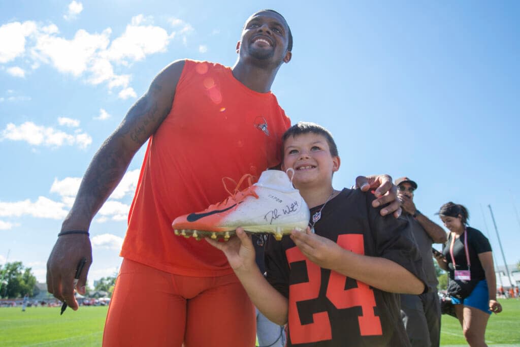 Cleveland Browns quarterback Deshaun Watson, left, poses for a picture with Tanner Hall after signing one of his cleats after an NFL football practice in Berea, Ohio, Saturday, July 30, 2022. (AP Photo/David Dermer)