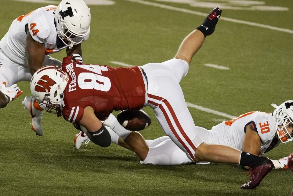 Wisconsin's Jake Ferguson fumbles the ball during the first half of an NCAA college football game against Illinois Friday, Oct. 23, 2020, in Madison, Wis. Illinois recovered the fumble and scored a touchdown on the play. (AP Photo/Morry Gash)