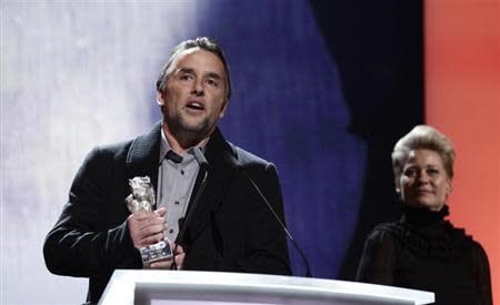 Director Richard Linklater makes a speech after receiving the Silver Bear for Best Director during the awards ceremony of the 64th Berlinale International Film Festival in Berlin February 15, 2014. In background is jury member Danish actress Trine Dyrholm. REUTERS/Tobias Schwarz