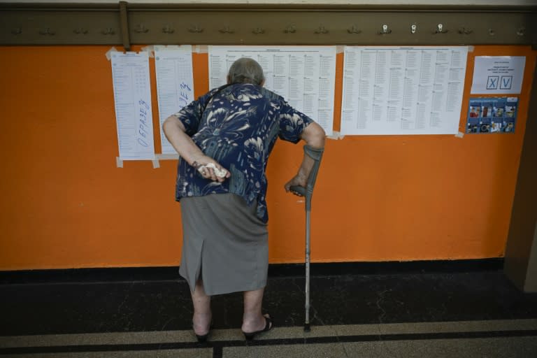 Una mujer mira las listas electorales en un colegio electoral durante los comicios legislativos y al Parlamento Europeo el 9 de junio de 2024, en la capital de Bulgaria, Sofía (Nikolay DOYCHINOV)