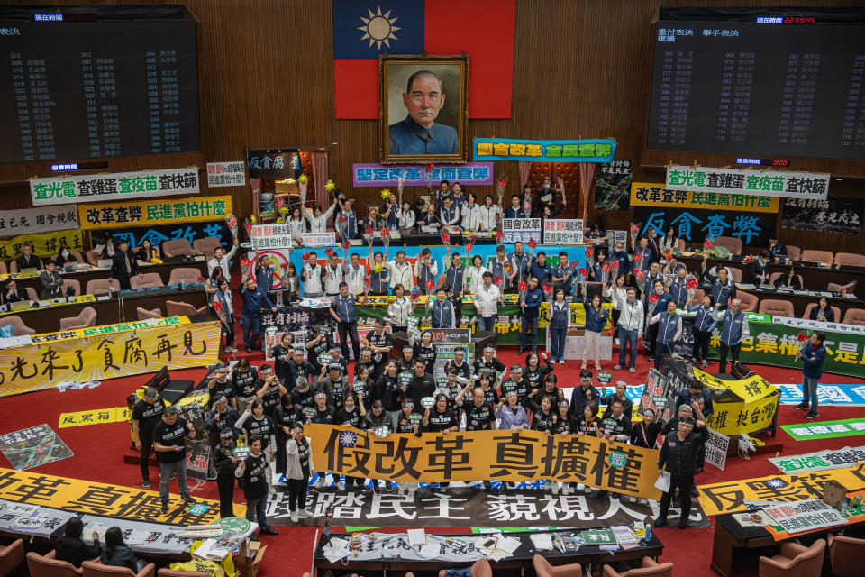 TAIPEI, TAIWAN - MAY 28: Lawmakers of the ruling Democratic Progressive Party (DPP) and opposition party Kuomintang (KMT) display signs during the vote for the parliament reform bill in Taipei, Taiwan, on May 28, 2024. The legislators of Democratic Progressive Party (DPP) protest against the opposition Kuomintang (KMT), and Taiwan People's Party (TPP) over the parliament reforms. (Photo by Man Hei Leung/Anadolu via Getty Images)