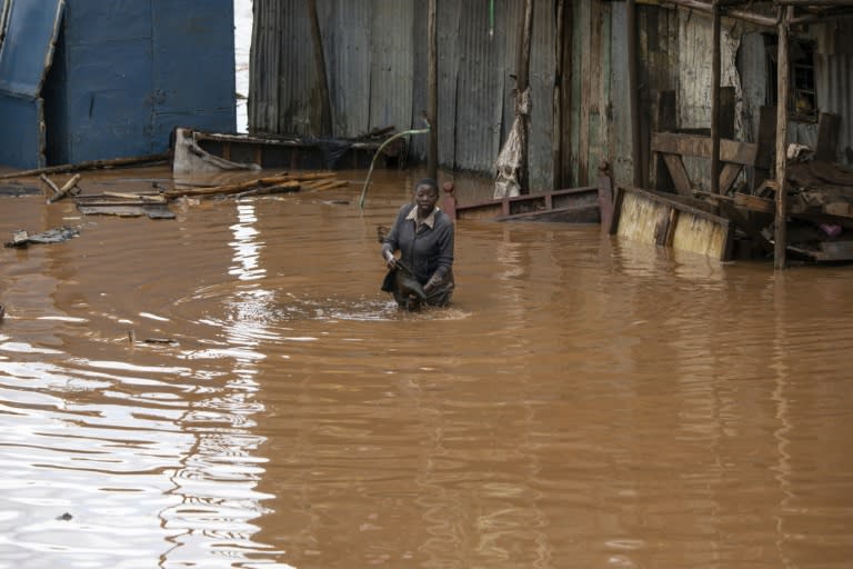Una mujer camina por una zona inundada en la barriada pobre de Mathare a causa de las fuertes lluvias en Nairobi, el 24 de abril de 2024 en la capital keniana (Simon Maina)