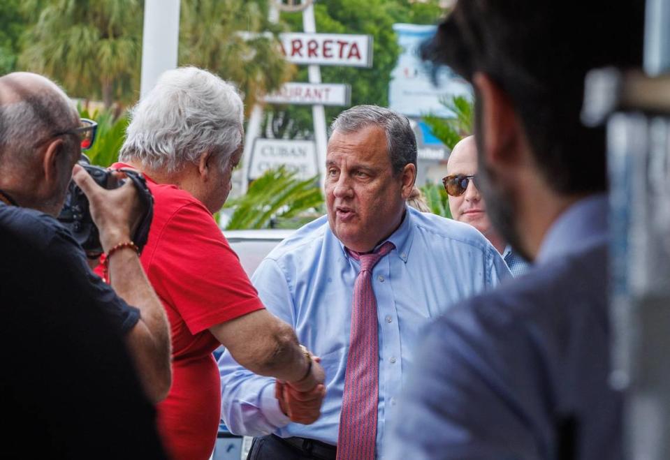 El candidato presidencial republicano Chris Christie saluda a los clientes a su llegada al icónico restaurante cubano Versailles, en La Pequeña Habana, el viernes 18 de agosto de 2023.