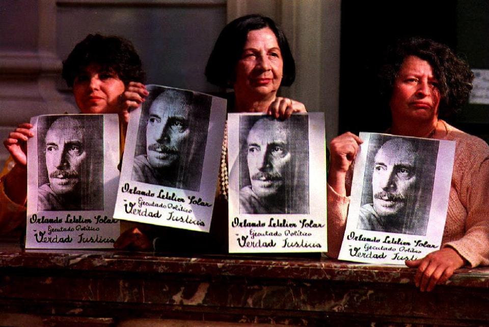 Members of a human rights group hold pictures of former Foreign Minister Orlando Letelier on Nov. 12, 1993, outside a Chilean court. The court sentenced to jail retired Gen. Manuel Contreras and Brig. Gen. Pedro Espinoza for planning the assassination of Letelier in Washington in 1976. Contreras was sentenced to seven and Espinoza to six years in jail.