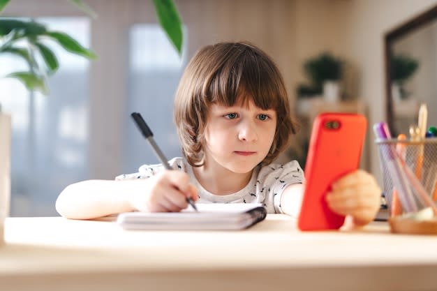 Volver a la escuela aprendizaje a distancia educación en línea niño niño  estudiando en casa con teléfono celular móvil | Foto Premium