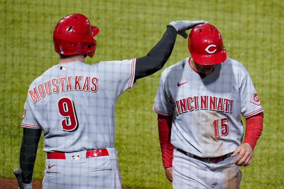 Cincinnati Reds' Nick Senzel, right is greeted by Mike Moustakas after he scored on a double by Jesse Winker during the eighth inning of a baseball game against the Pittsburgh Pirates, Tuesday, May 11, 2021, in Pittsburgh. (AP Photo/Keith Srakocic)