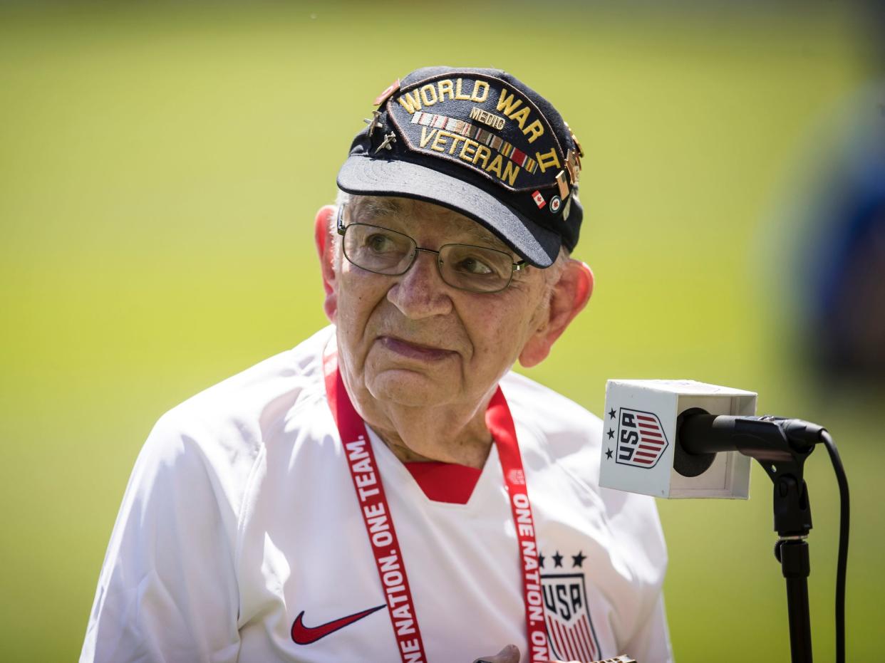 The US World War II veteran Pete DuPré in front of a microphone wearing a US national team jersey..