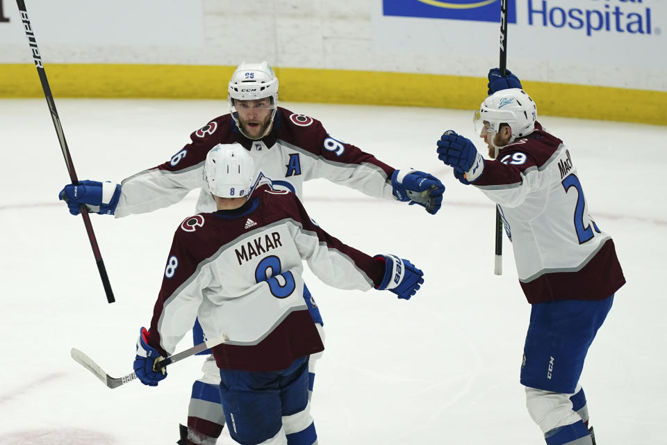 Colorado Avalanche right wing Mikko Rantanen (96), center Nathan MacKinnon (29) and defenseman Cale Makar (8) celebrate after the goal by teammate Gabriel Landeskog during the second period of Game 4 of the NHL hockey Stanley Cup Finals against the Tampa Bay Lightning on Wednesday, June 22, 2022, in Tampa, Fla. (AP Photo/John Bazemore)