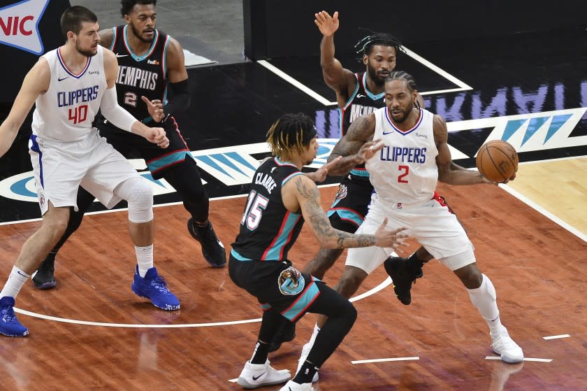 Clippers forward Kawhi Leonard handles the ball between Memphis Grizzlies' Brandon Clarke and Justise Winslow on Feb. 25.