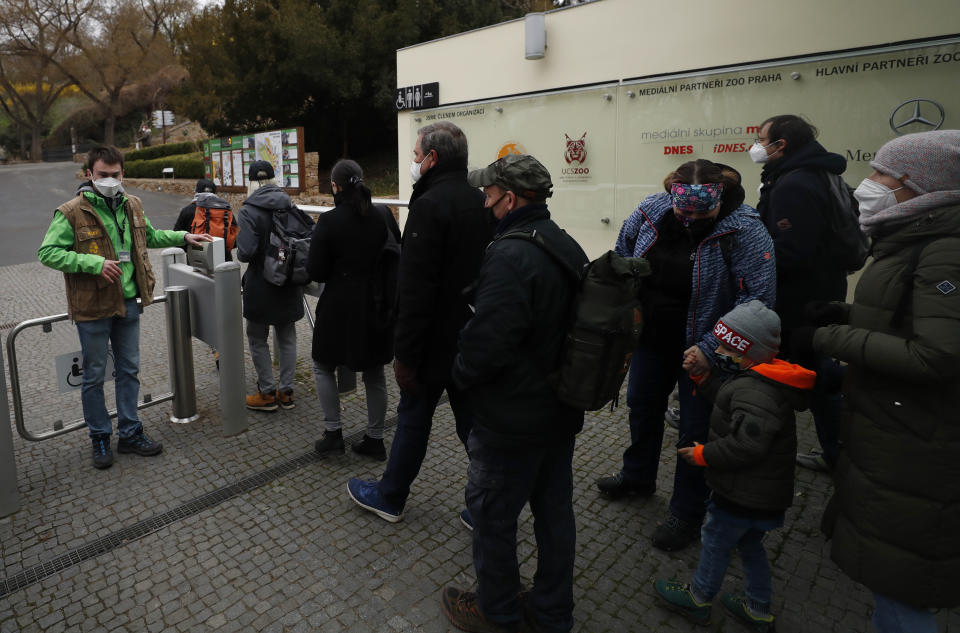 Visitors line up to enter the zoo in Prague, Czech Republic, Monday, April 12, 2021. The Czech government has agreed to start easing the tight lockdown, caused by the COVID-19 pandemic, in one of the hardest-hit European countries. Children up to the fifth grade will be back at schools while the stores selling clothes and shoes for kids, laundries, outdoor farmers markets, zoo and botanical gardens are reopened. (AP Photo/Petr David Josek)