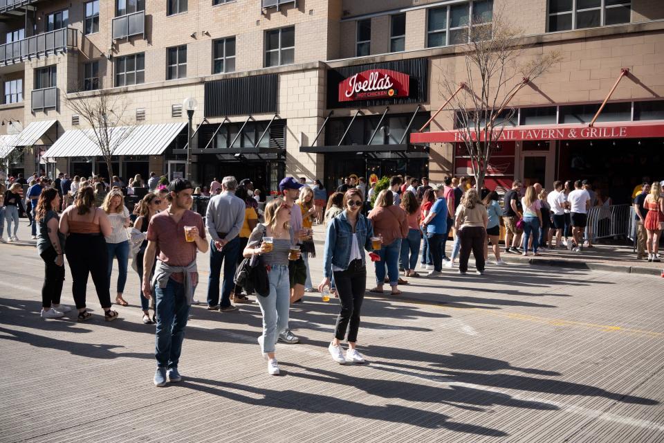 People wait in a long line outside Holy Grail Tavern and Grille on Saturday at The Banks in Cincinnati, Ohio.