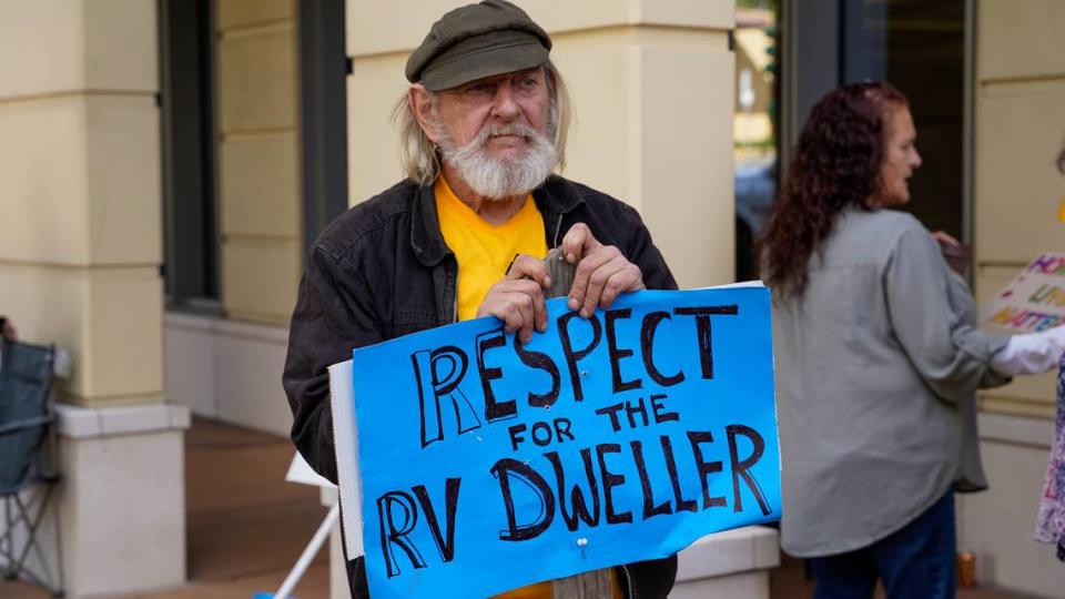 An Oklahoma Avenue Safe Parking Site resident holds a sign during a demonstration Tuesday afternoon, Jan. 23, 2024, at the Katcho Achadjian Government Center. The San Luis Obispo County chapter of the California Homeless Union filed a lawsuit against the county and the Community Action Partnership of San Luis Obispo related to the operation of the safe parking site and treatment of its residents.