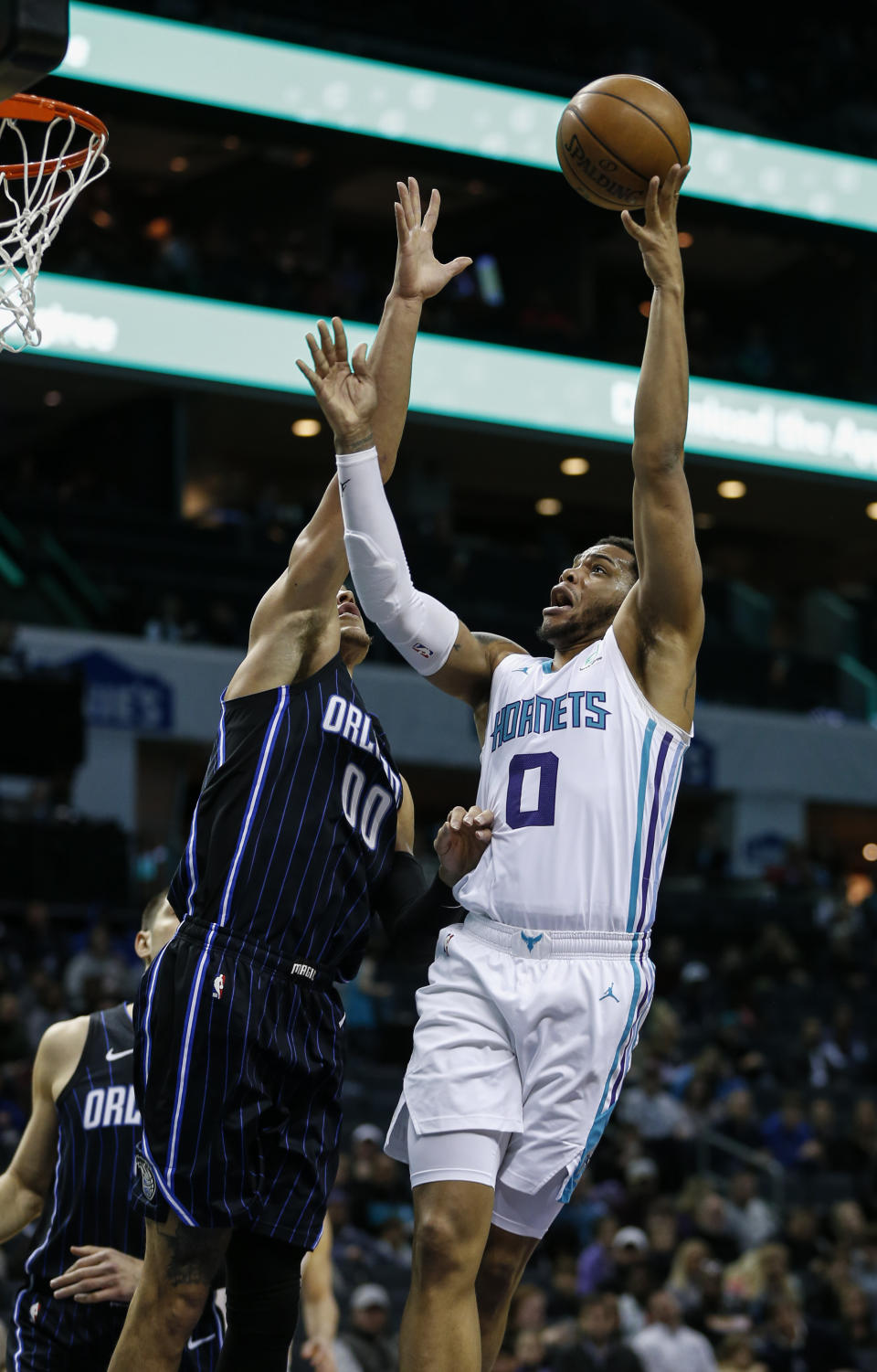 Charlotte Hornets forward Miles Bridges, right, shoots over Orlando Magic forward Aaron Gordon in the first half of an NBA basketball game in Charlotte, N.C., Monday, Jan. 20, 2020. (AP Photo/Nell Redmond)