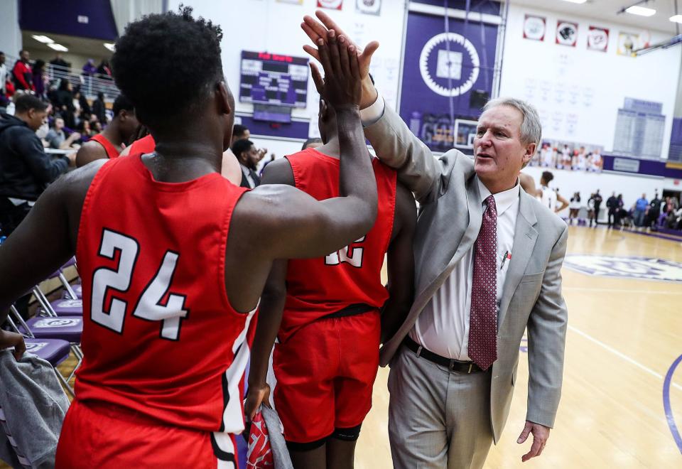 From right, Pike Red Devils head coach Bill Zych congratulates players after they defeated the Ben Davis Giants, 78-67, in Marion County quarterfinals at Ben Davis High School in Indianapolis, Wednesday, Jan. 9, 2019. 
