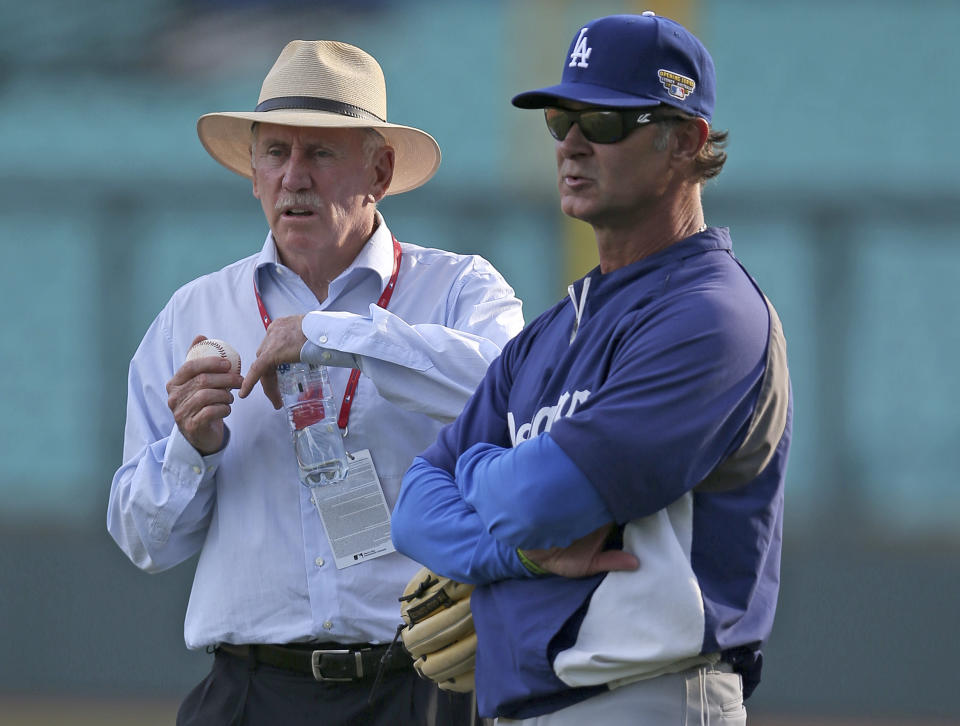 Los Angeles Dodgers manager Don Mattingly, right, talks with former Australian cricket captain Ian Chappell while the Dodgers train in Sydney, Thursday, March 20, 2014. The Diamondbacks and the Los Angeles Dodgers open the Major League Baseball regular season with games on Saturday and Sunday. (AP Photo/Rick Rycroft)