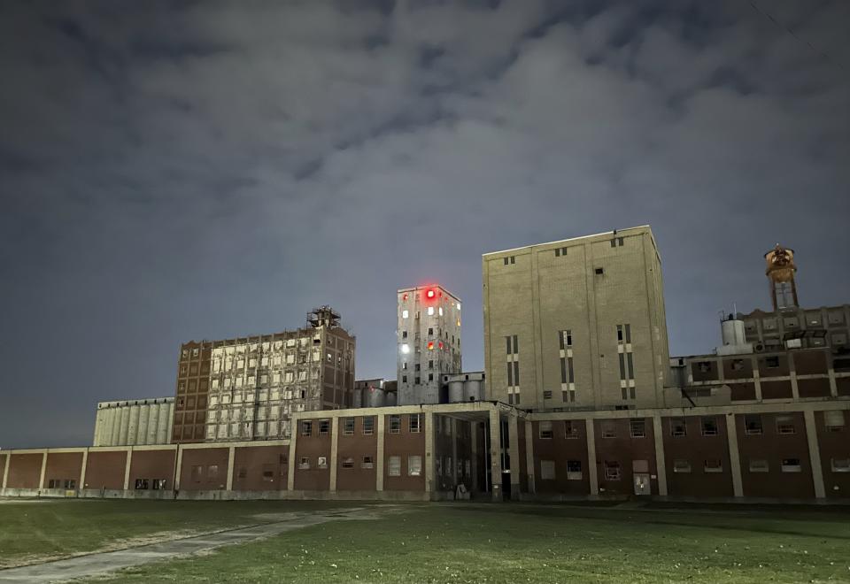 Holiday lights blaze from the headhouse of the former Pillsbury Mills in Springfield, Ill., on Wednesday, Dec. 20, 2023. While awaiting funding and authority to demolish the factory and redevelop the site, the nonprofit Moving Pillsbury Forward has ginned up interest in the history and future of the plant, including installing the lights. Chris Richmond, president of Moving Pillsbury Forward, said the lights “bring an energy to the site that has not been there for years. (They) bring with them a message that something positive is happening.” The mill operated under Minneapolis-based Pillsbury and another owner for 71 years but has been vacant nearly a quarter-century. (AP Photo/John O’Connor)