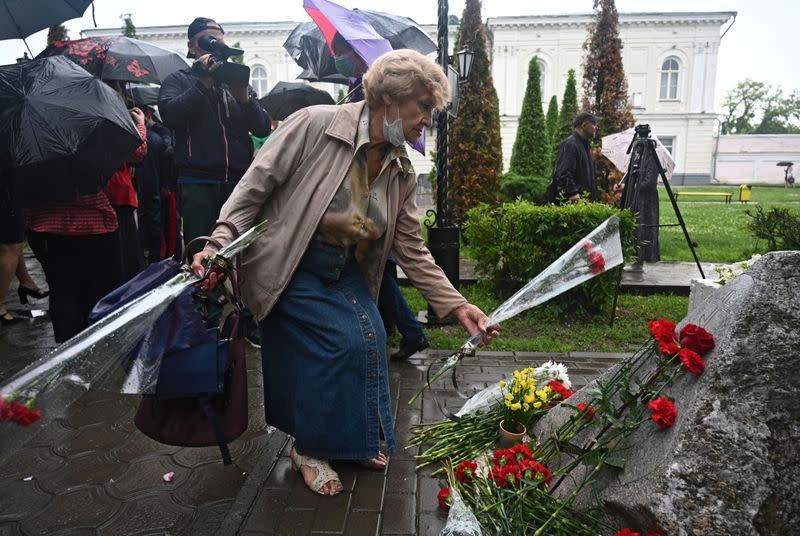 A woman lays flowers at a memorial for the victims of the protest against rising food prices that was brutally suppressed by the Soviet Army in 1962, in Novocherkassk