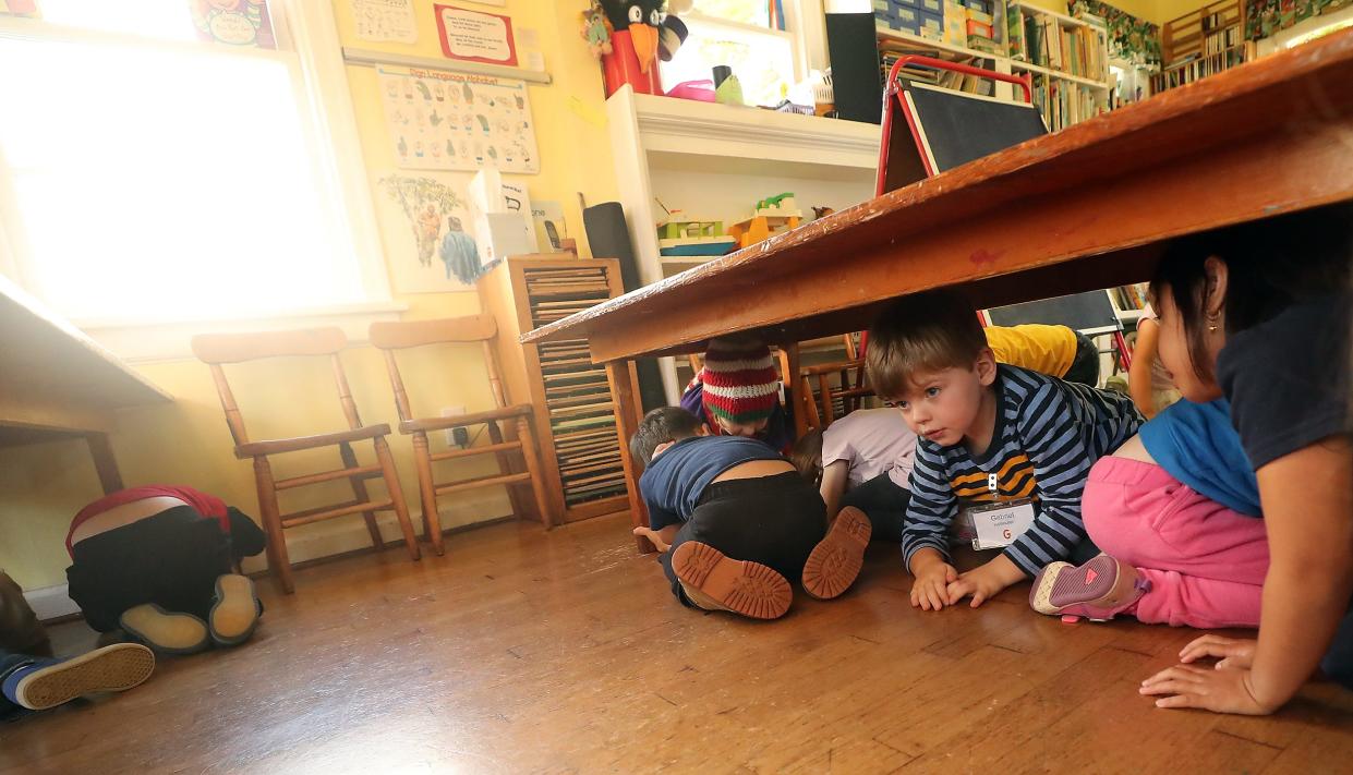 Preschoolers take positions under a table during a simulated earthquake drill. The annual Great ShakeOut at 10:20 a.m. on Thursday will help residents to “Drop, Cover, and Hold On” during a major earthquake.