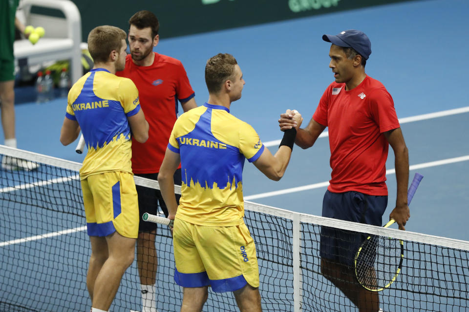 Rajeev Ram, right, and Austin Krajicek of the USA shake hands after their victory to Illya Beloborodko, left, and Oleksii Krutykh of Ukraine during a Davis Cup qualifier doubles tennis match between Ukraine and USA, in Vilnius, Lithuania, Friday, Feb. 2, 2024. (AP Photo/Mindaugas Kulbis)
