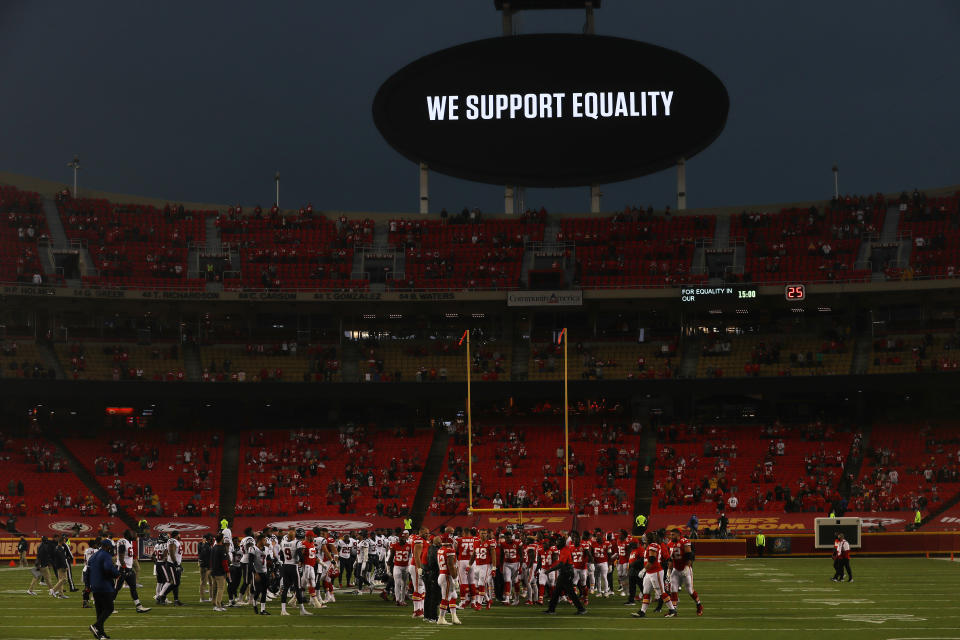 Players from the Kansas City Chiefs and Houston Texans unite in a moment of silence in front of the video board that reads "We support equality."