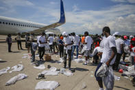 Haitians deported from the United States recover their belongings scattered on the tarmac of the Toussaint Louverture airport in Port-au-Prince, Haiti Tuesday, Sept. 21, 2021 (AP Photo/Joseph Odelyn)