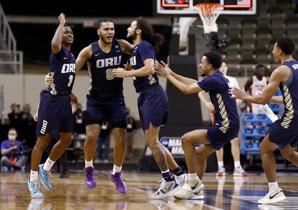 Max Abmas #3, Kevin Obanor #0 and Kareem Thompson #2 of the Oral Roberts Golden Eagles celebrate after defeating the Florida Gators in the second round game of the 2021 NCAA Men's Basketball Tournament at Indiana Farmers Coliseum on March 21, 2021 in Indianapolis, Indiana. Oral Roberts defeated Florida 81-78. (Photo by Maddie Meyer/Getty Images)