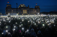 People hold up their cell phones as they protest against the AfD party and right-wing extremism in front of the Reichstag building in Berlin, Germany, Sunday, Jan. 21, 2024. (AP Photo/Ebrahim Noroozi)