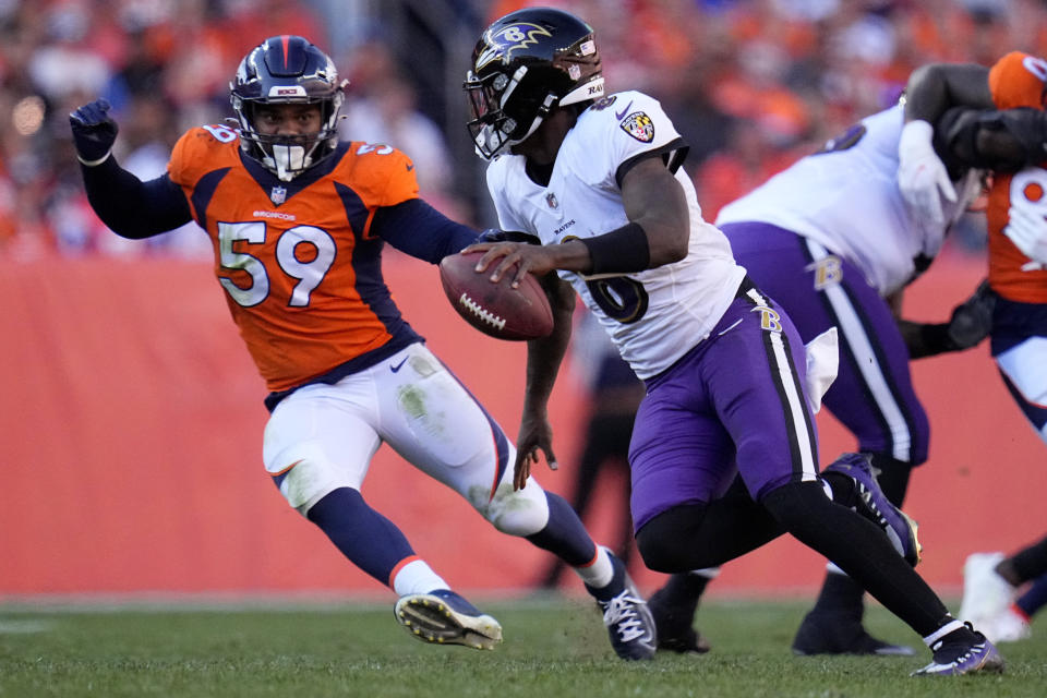 Baltimore Ravens quarterback Lamar Jackson (8) looks to throw under pressure from Denver Broncos linebacker Malik Reed (59) during the second half of an NFL football game, Sunday, Oct. 3, 2021, in Denver. (AP Photo/Jack Dempsey)