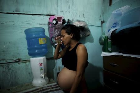 Patricia Araujo, 23, who is seven months pregnant, drinks water inside her stilt house, a lake dwelling also known as palafitte or 'Palafito', in Recife, Brazil, February 8, 2016. REUTERS/Nacho Doce