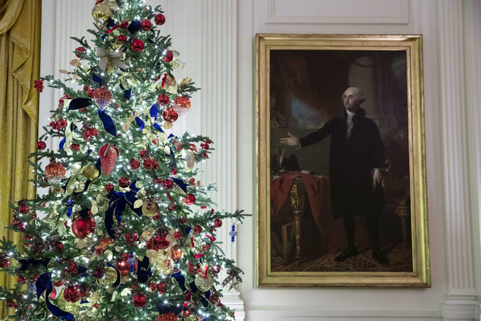 Un árbol de Navidad aparece al lado de un cuadro del expresidente George Washington en el Salón Este de la Casa Blanca, el lunes 2 de diciembre del 2019. (AP Foto/Alex Brandon)