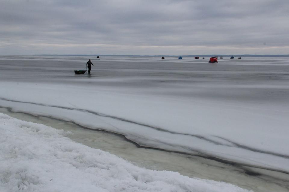 A sturgeon spearer pulls a sled Saturday morning toward shacks placed on the ice along the west shore on Lake Winnebago.