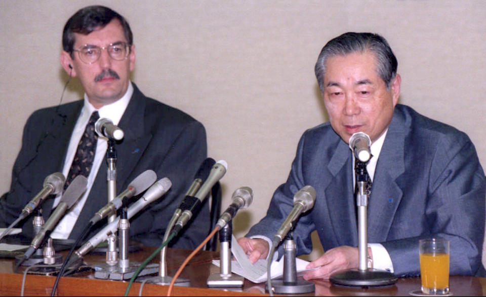 FILE - In this April 12, 1996, file photo, then Mazda Mortor Corp. Vice President Henry Wallace, left, listens to then President Yoshihiro Wada during a press conference at their headquarters in Hiroshima, western Japan. U.S. automaker Ford Motor Co. helped engineer a turnaround at Japan’s Mazda Motor Corp., forming an alliance in 1979 and taking a 25 percent stake. That was raised to 33.4 percent in 1996, a controlling share in Japan.(Kyodo News via AP, File)