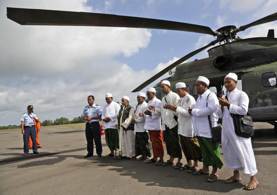 Muslim clerics pray before embarking on a flight with Indonesian Air Force NAS 332 Super Puma helicopter, to fly over the Java Sea to offer prayers for victims of AirAsia flight QZ 8501, at Iskandar Airport in Pangkalan Bun, January 6, 2015. Search teams including divers took advantage of a let-up in bad weather on Tuesday to try to reach the wreckage of an AirAsia jet that crashed nine days ago, and to recover bodies and find its black box flight recorders. Indonesian officials believe they may have located the tail and parts of the fuselage of the Airbus A320-200 at the bottom of the Java Sea, but strong currents, high winds and big waves have hindered attempts to investigate the debris. REUTERS/Achmad Ibrahim/Pool (INDONESIA - Tags: TRANSPORT DISASTER RELIGION)