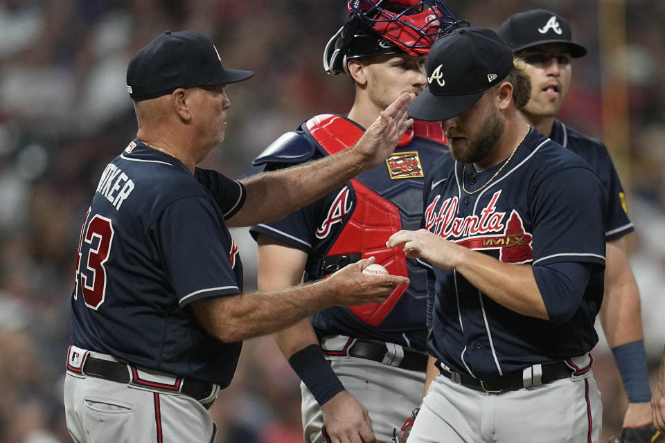 Atlanta Braves relief pitcher A.J. Minter, front right, is taken out of a baseball game by manager Brian Snitker (43) in the eighth inning against the Cleveland Guardians, Monday, July 3, 2023, in Cleveland. (AP Photo/Sue Ogrocki)