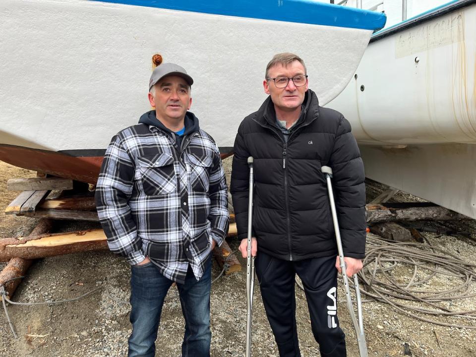 Richard Martin (right) and his fishing partner Merricks Foster are seen here on the waterfront in Shoe Cove, a small fishing community on the Baie Verte Peninsula. In the background is their fishing vessel, Shoe Cove Challenger.