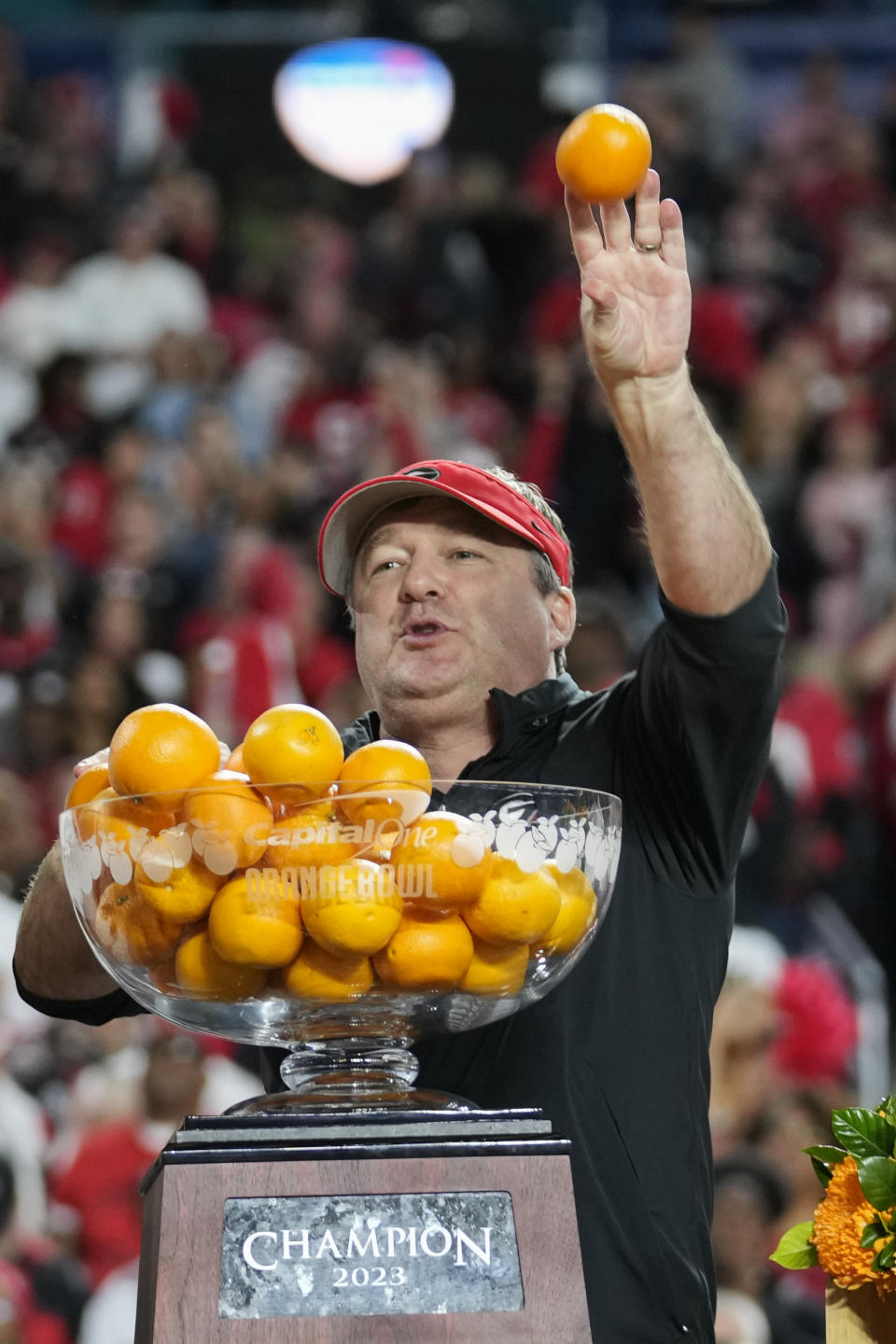 Georgia head coach Kirby Smart tosses oranges from the trophy after Georgia defeated Florida State in the second half of the Orange Bowl NCAA college football game, Saturday, Dec. 30, 2023, in Miami Gardens, Fla. (AP Photo/Rebecca Blackwell)