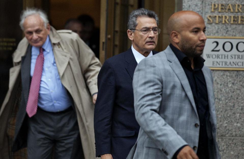 Rajat Gupta, center right, leaves federal court in New York on Wednesday, Oct. 24, 2012 after the former Goldman Sachs and Procter & Gamble Co. board member was sentenced Wednesday to 2 years in prison for feeding inside information about board dealings with a billionaire hedge fund owner who was his friend. At left is Gupta's attorney, Gary Naftalis. (AP Photo/Craig Ruttle)