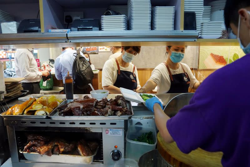 FILE PHOTO: Staff members prepare takeaway food at a restaurant in Hong Kong