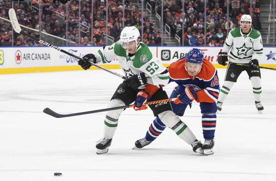 Dallas Stars' Wyatt Johnston (53) and Edmonton Oilers' Zach Hyman (18) battle for the puck during first-period NHL hockey game action in Edmonton, Alberta, Saturday, Nov. 5, 2022. (Jason Franson/The Canadian Press via AP)