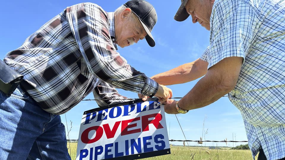 Gaylen Dewing and Marvin Abraham put up a sign opposing the Summit pipeline east of Bismarck, N.D. in August 2023. - Jack Dura/AP