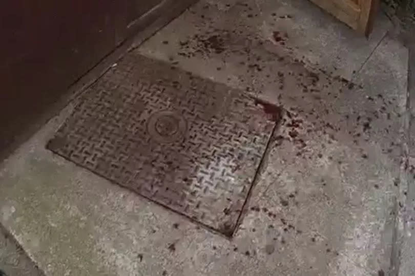 The blood-covered manhole cover, underneath where the drugs were stored