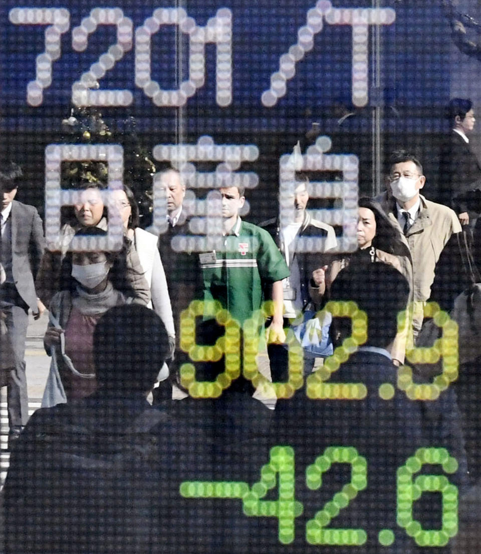 With passersby reflected on the electronic stock board, the stock price of Nissan Motor shows the day's loss, in green, at a securities firm in Tokyo, Tuesday, Nov. 20, 2018. Nissan Chairman Carlos Ghosn, who became one of the auto industry's most powerful executives by engineering a turnaround at the Japanese manufacturer, was arrested Monday and will be fired for allegedly underreporting his income and misusing company funds, the automaker said.(Daisuke Suzuki/Kyodo News via AP)