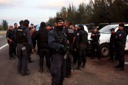 Federal policemen gather outside a ranch where a gunfight between hitmen and federal forces left several casualties in Tanhuato, state of Michoacan, May 22, 2015. REUTERS/Alan Ortega