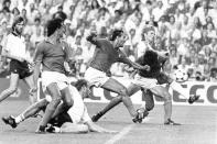FILE - Paolo Rossi, right, puts his head down to hit the ball from a ruck of players, to score Italy's first goal, in the World Cup soccer final at Madrid's Santiago Bernabeu stadium. Other players are from left, Italy's Alessandro Altobelli, West Germany's Hans-Peter Briegel, Italy's Antonio Cabrini and West Germany's Bernd Foerster. Rossi, the star of Italy’s World Cup-winning team in 1982, has reportedly died at age 64. He was the leading scorer in the '82 World Cup and was also FIFA's player of the year. (AP Photo/Dave Caulkin, File)