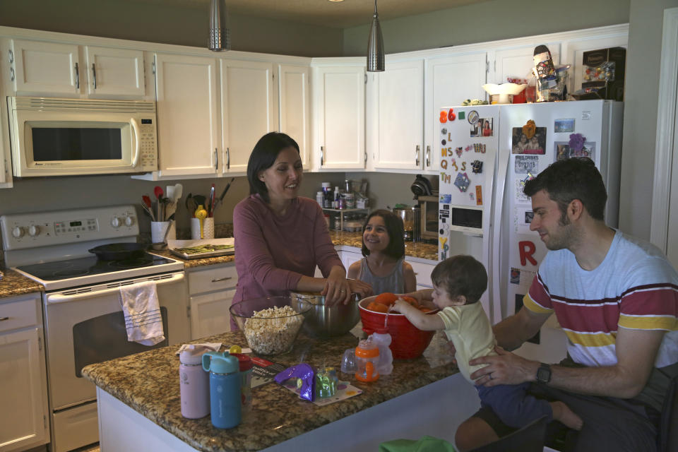 Katherine Rutigliano prepara la comida para su esposo Elio y sus hijos Theo y Charlotte en su casa de un suburbio de Phoenix el 16 de marzo del 2020. Cuando se mudaron allí, pensaron que nunca volverían a ver un demócrata como ellos, pero se equivocaron. (AP Photo/Darío López-Mills)