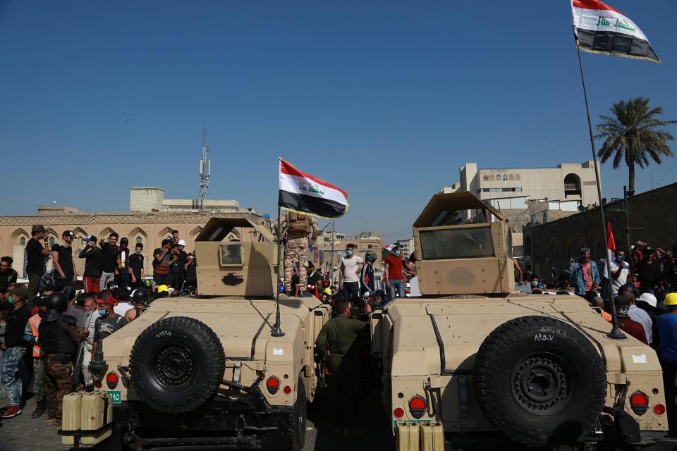 Army soldiers try to prevent anti-government protesters from crossing the al- Shuhada (Martyrs) bridge in central Baghdad, Iraq, Wednesday, Nov. 6, 2019. (AP Photo/Khalid Mohammed)